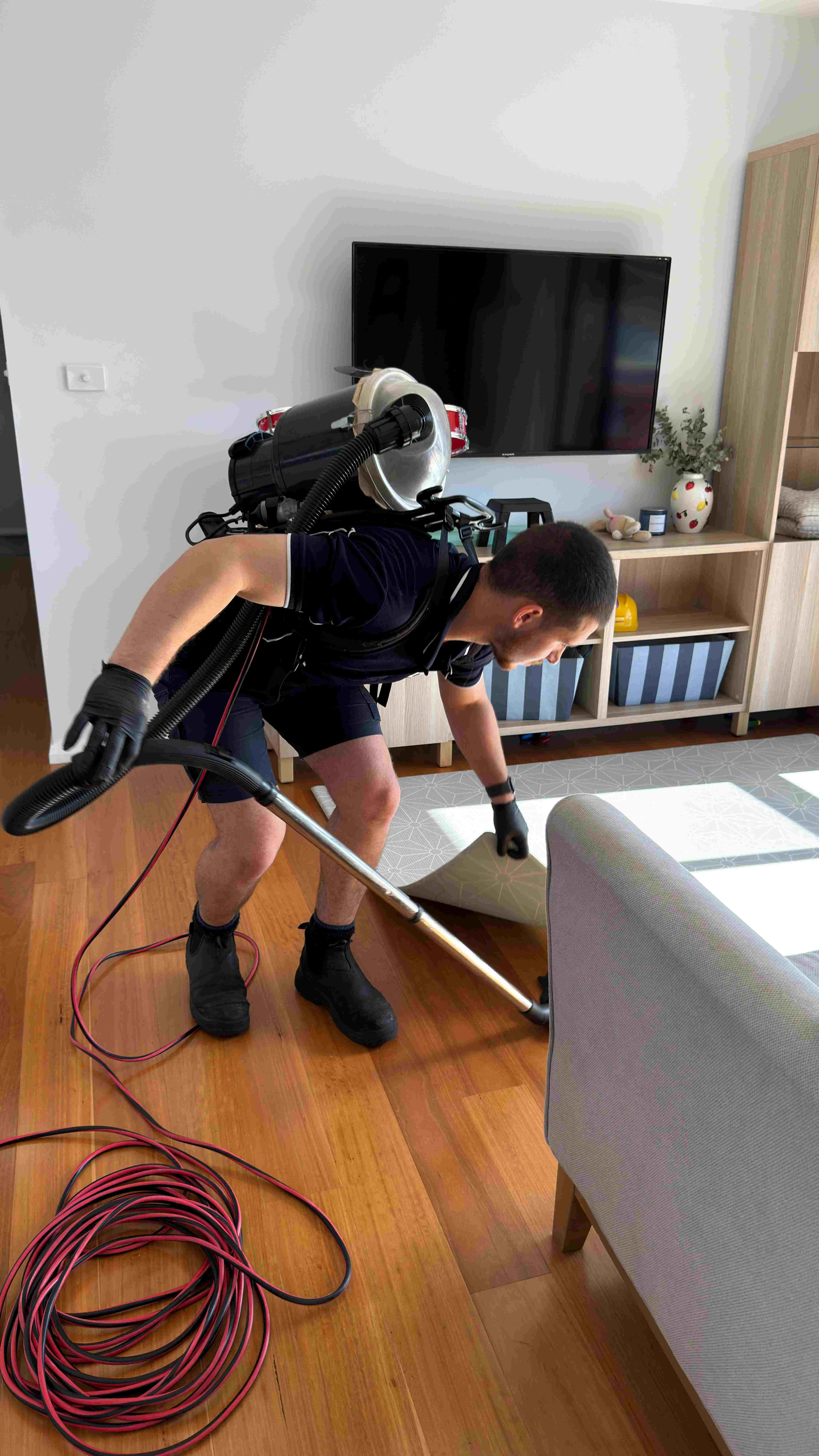 Gleam Clean Co. cleaner vacuuming an Airbnb living room