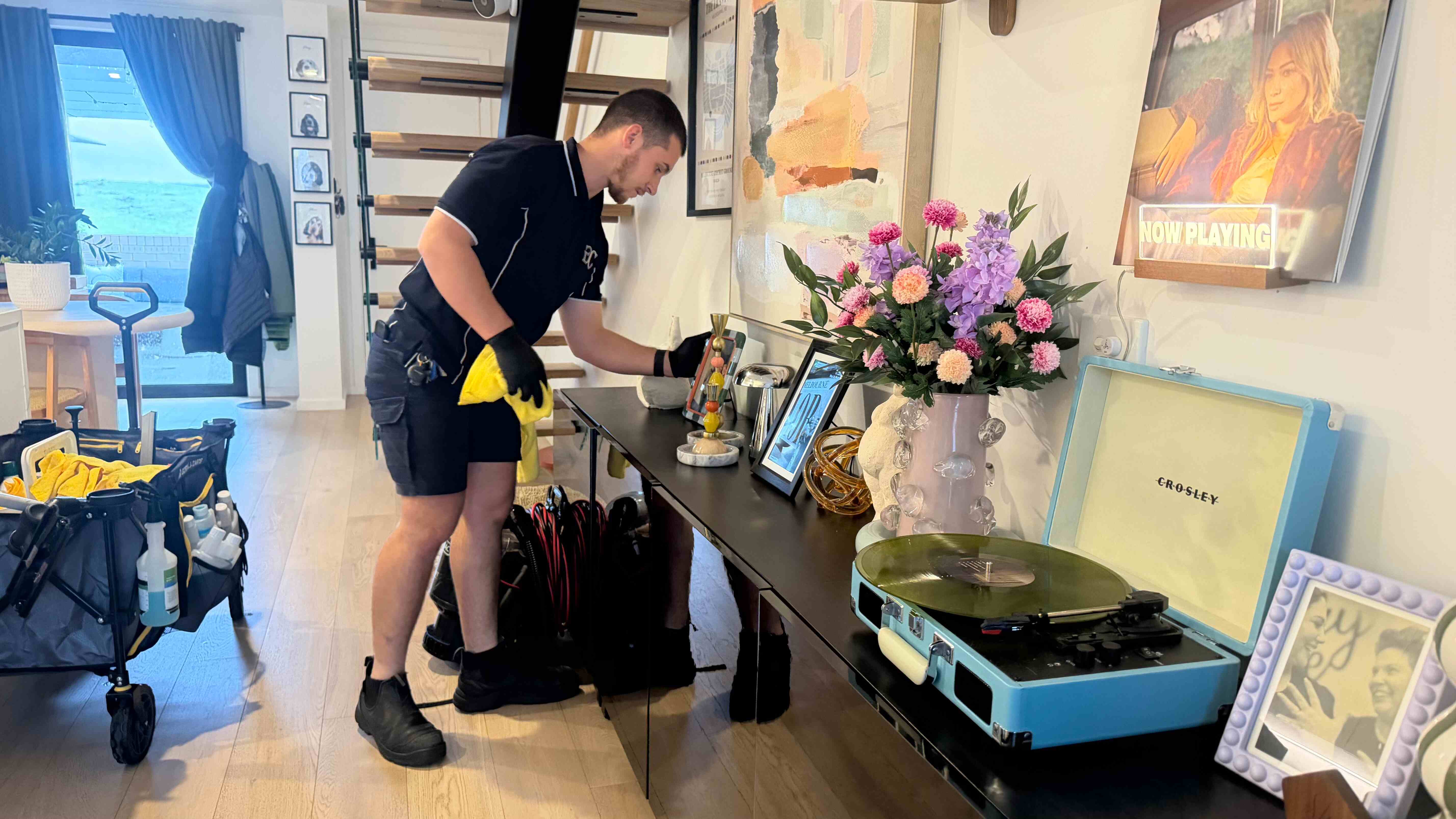 Gleam Clean Co. cleaner dusting and detailing a living room console