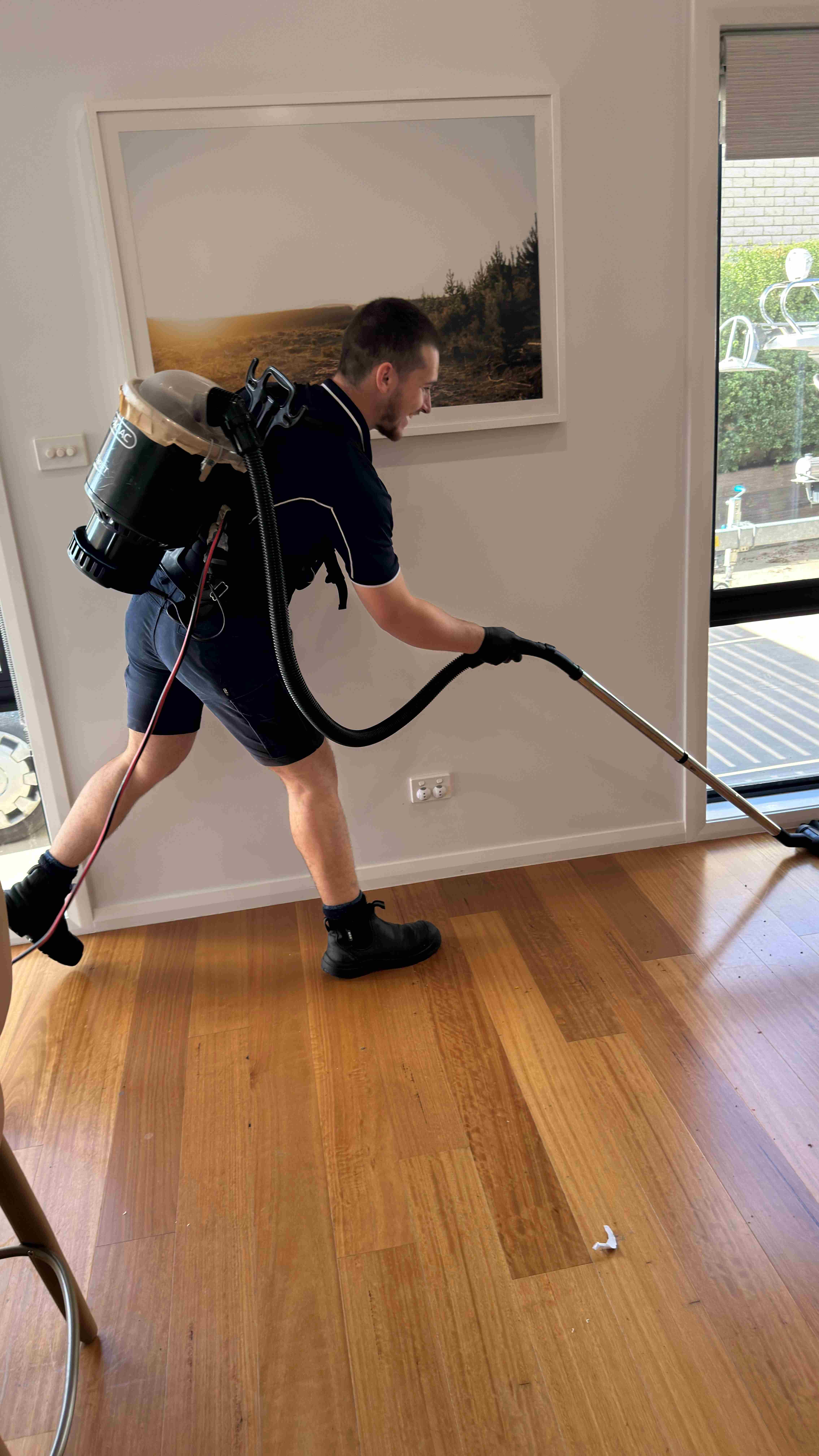 Gleam Clean Co. cleaner vacuuming a commercial office floor